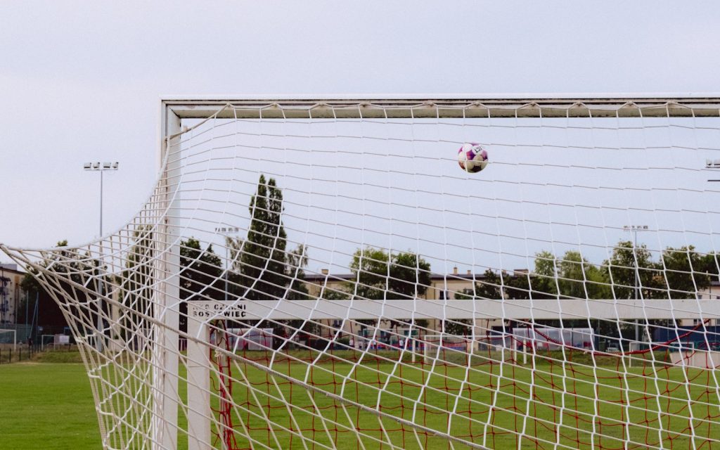A football flying toward the goal net