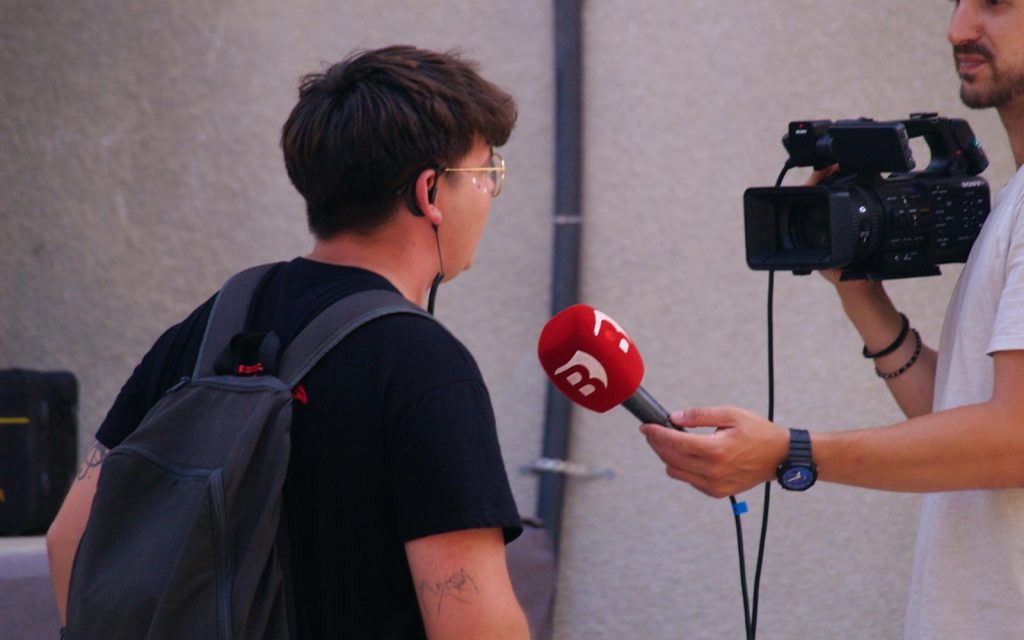 A person being interviewed with a microphone and camera
