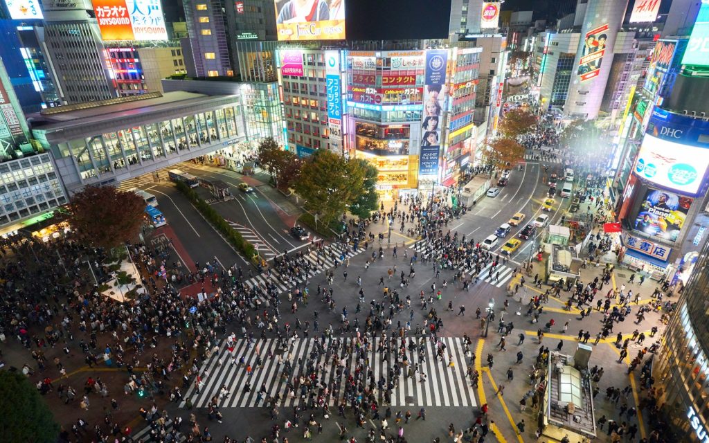 Crowds crossing the Shibuya scramble intersection in Tokyo at night