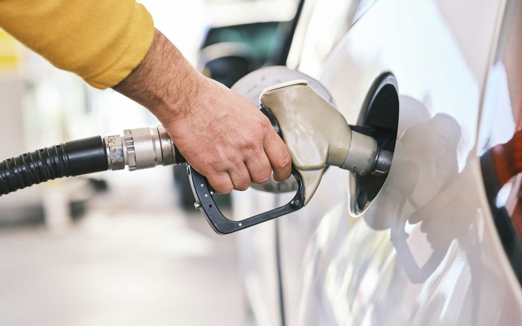 A driver refuelling a car at a gas station pump