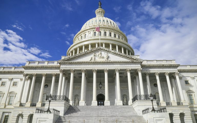 The US Capitol building with its white dome against a blue sky
